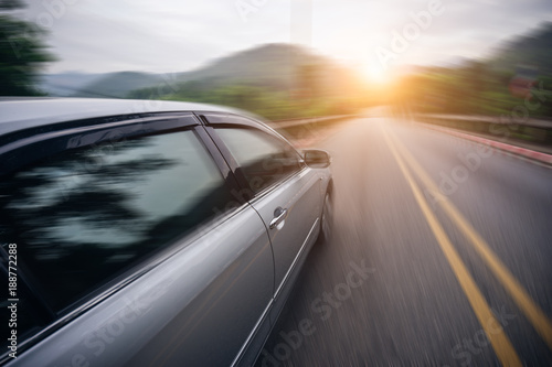 Car driving on asphalt road at sunset go to travel, motion blur