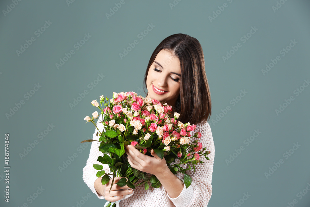 Young smiling woman with flowers on color background Young smiling woman with flowers on color background