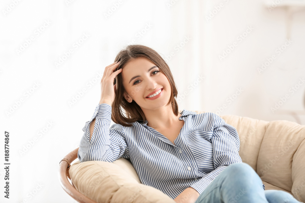 Young smiling woman resting in armchair indoors Young smiling woman resting in armchair indoors