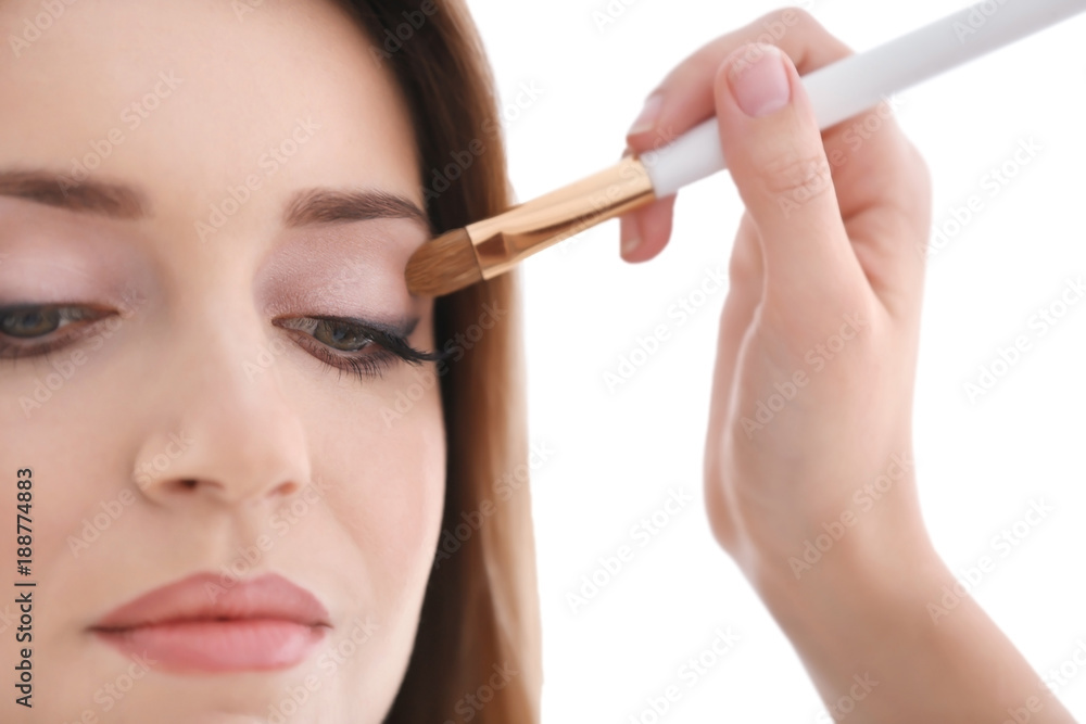 Professional artist creating makeup for model on white background Professional artist creating makeup for model on white background