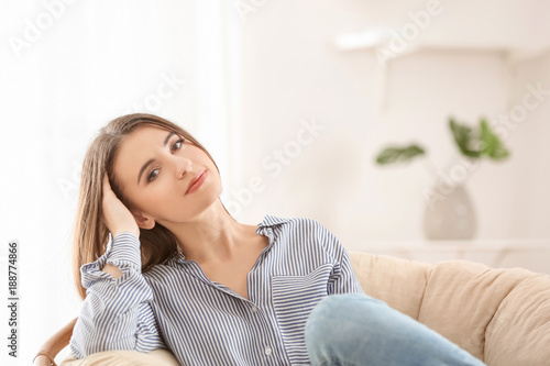 Young smiling woman resting in armchair indoors