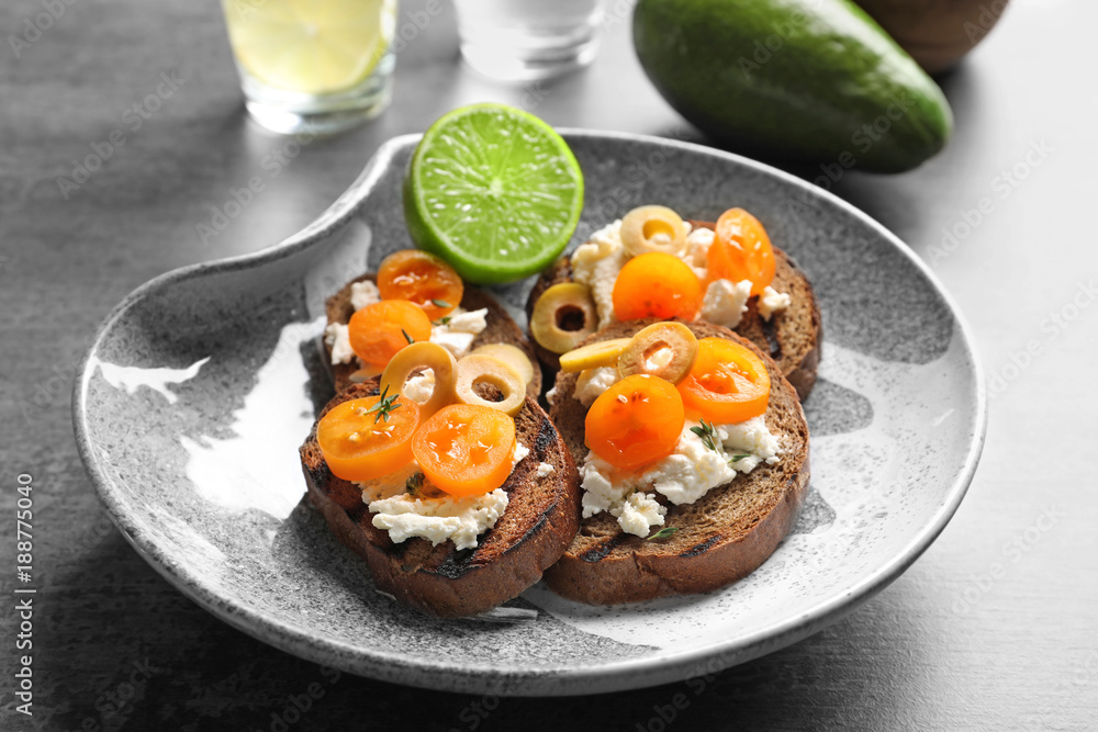 Tasty bruschettas with cherry tomatoes and olives on plate