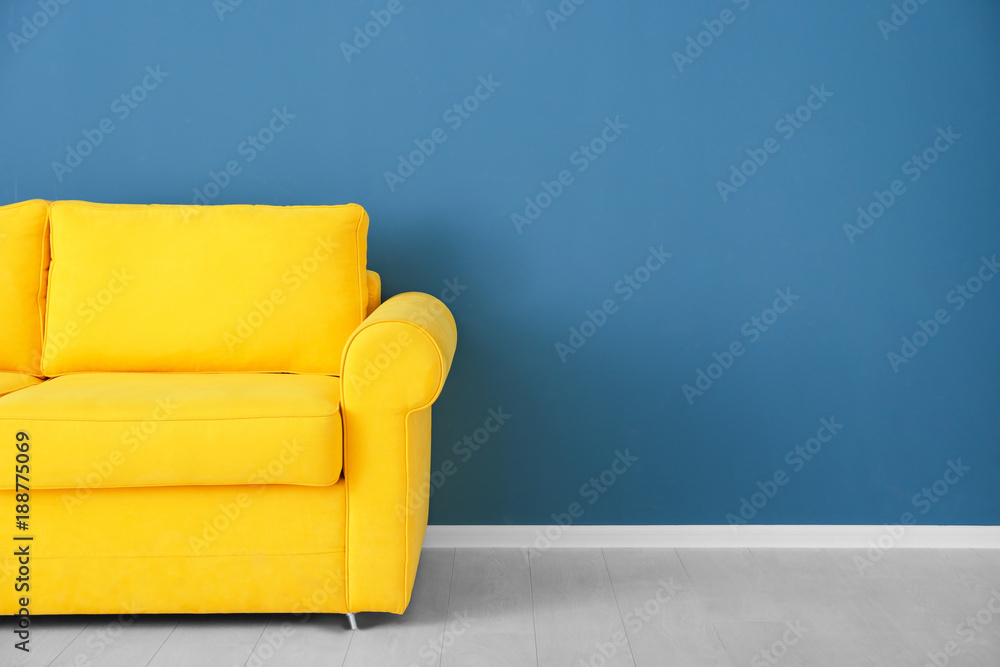 Bright yellow couch near color wall - obrazy, fototapety, plakaty 