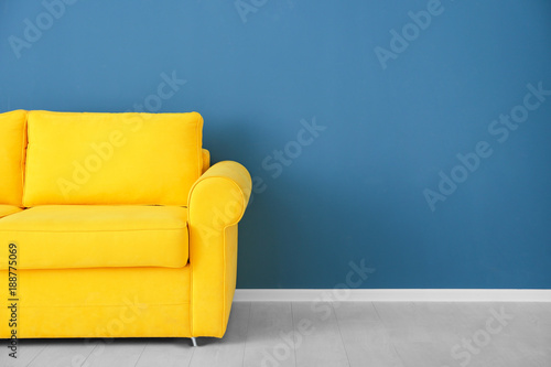 Bright yellow couch near color wall photo
