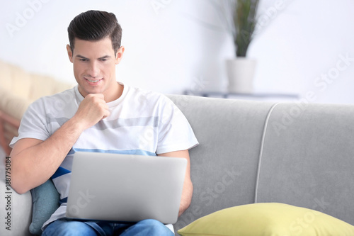 Young man using laptop on c...