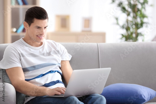Young man using laptop on c...