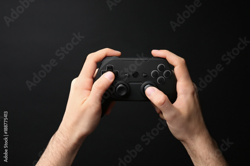 Man holding video game controller on black background