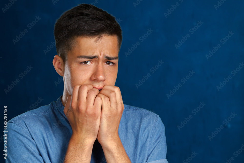 Closeup portrait of a man biting his nails and looking at camera Closeup portrait of a man biting his nails and looking at camera