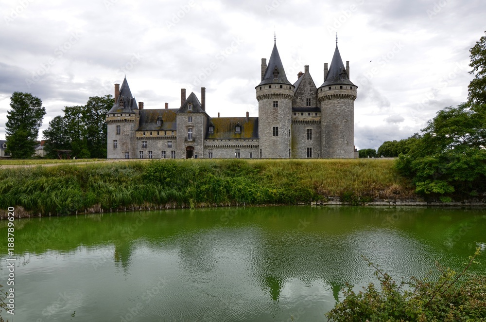 Castle of Sully-sur-Loire, Loire region, France. Snap of 30 June 2017 at 18:21. Captured at the entrance of the castle park. White clouds moving on blue sky. Towers well visible in the image.