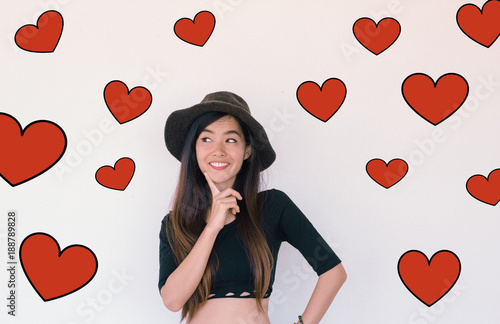 Valentines Day concept- Headshot portrait of a hipster young asian woman smiling with red heart illustration doodle icon at the back ground photo