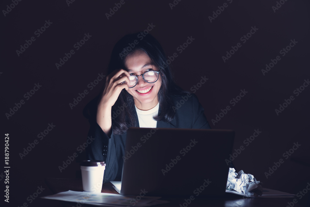 Working hard for online business, asian smiling businesswoman sitting at the desk with notebook, female teenager looking so happy with hard work