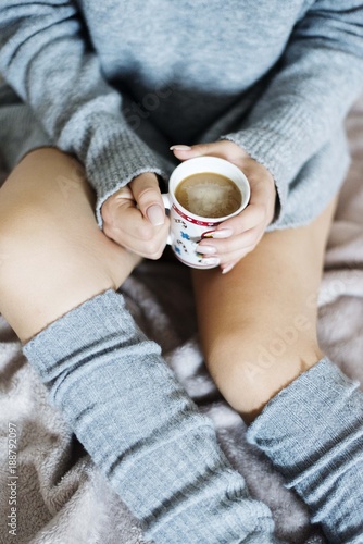 girl in bed holding cup of coffee