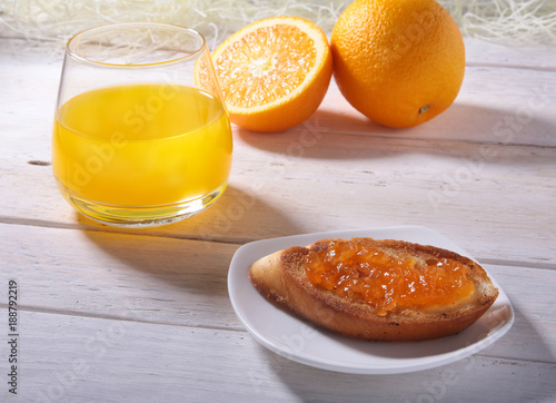 Morning Breakfast set with orange jam on bread toast and juice in glass.