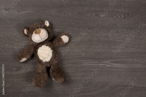 Brown teddy bear on wooden background, top view