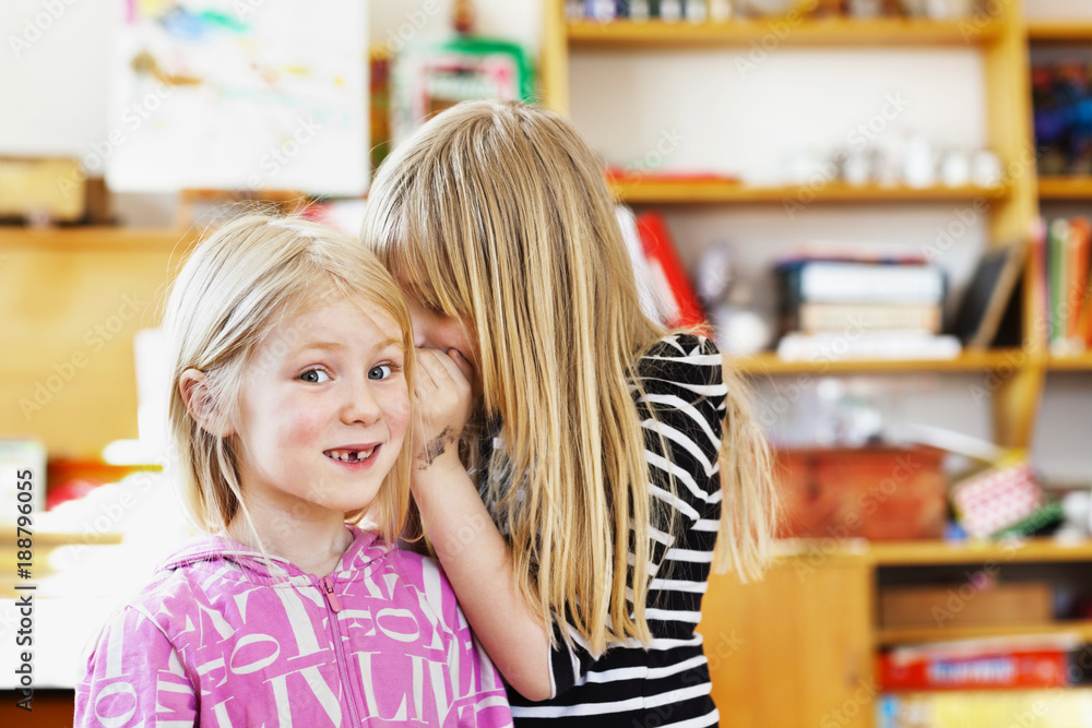 Two young girls gossiping Two young girls gossiping