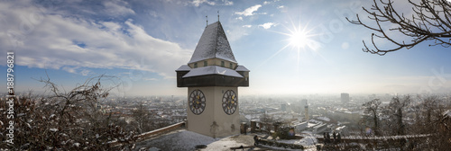 panorama of the schlossberg hill with the landmark clocktower uhrturm in winter, graz, austria