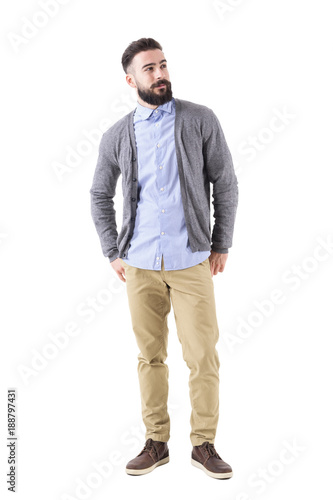 Obraz na plátně Well dressed man fashion model in gray cardigan looking up with hands in back pockets