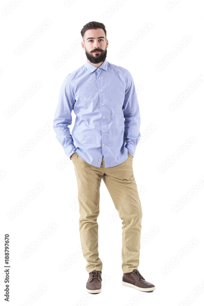 Confident successful serious business man with hands in pockets looking at camera. Full body length portrait isolated on white studio background. Confident successful serious business man with hands in pockets looking at camera. Full body length portrait isolated on white studio background.