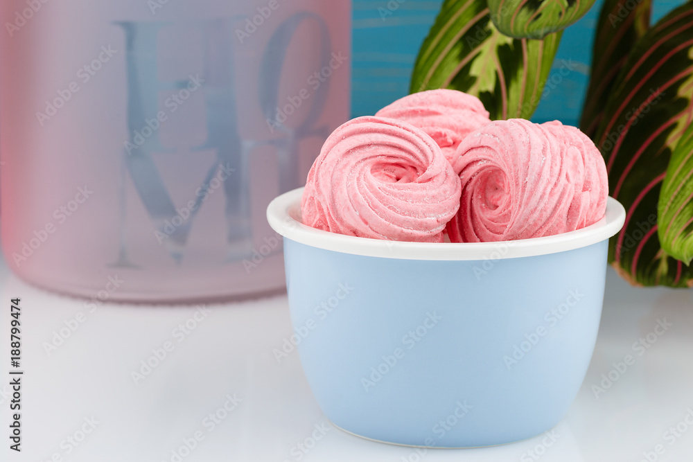 Homemade pink zephyr or marshmallow on blue bowl Homemade pink zephyr or marshmallow on blue bowl