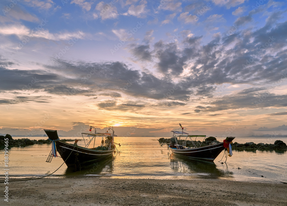 Island beach with a long tail boats at colourful sunset background Island beach with a long tail boats at colourful sunset background