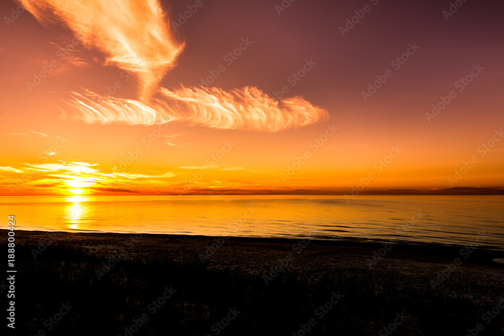 Sunset beach, sun on the sky in orange color and sea, silhouette landscape, Poland