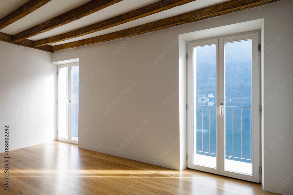 Obraz premium Empty room with large windows and antique beams