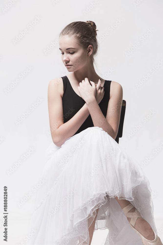 The teen ballerina in white pack sitting on chair The teen ballerina in white pack sitting on chair