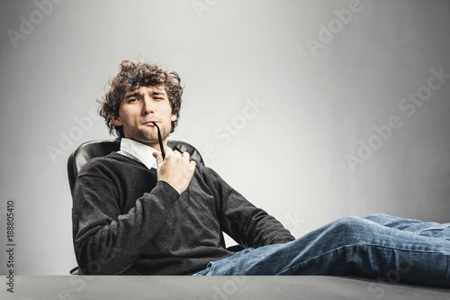 Man sitting with legs on the desk.