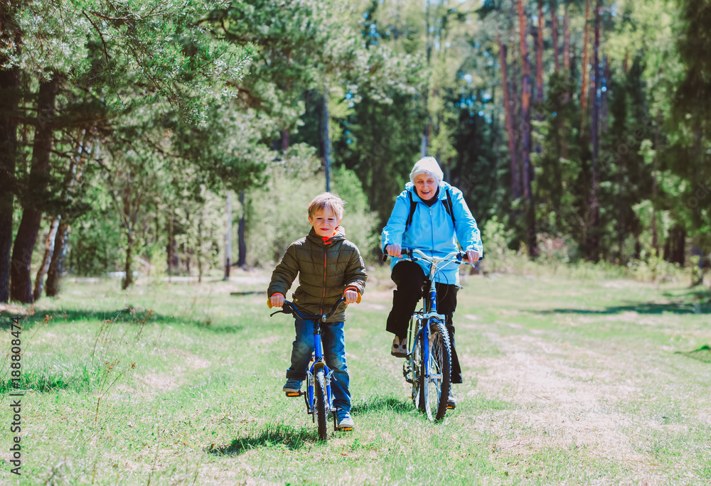 Fototapeta premium active senior grandmother with grandson riding bikes in nature