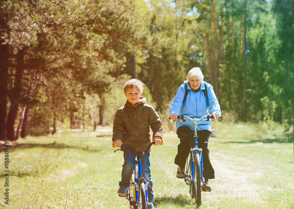 Fototapeta premium active senior grandmother with grandson riding bikes in nature