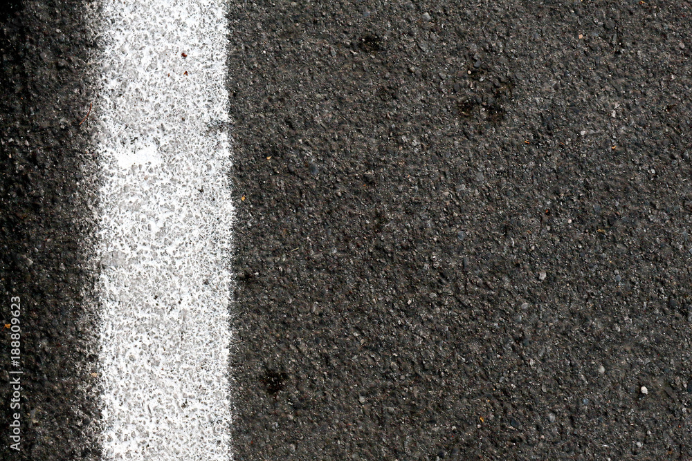 Fototapeta premium Closeup of road surface with white paint line, vertical.