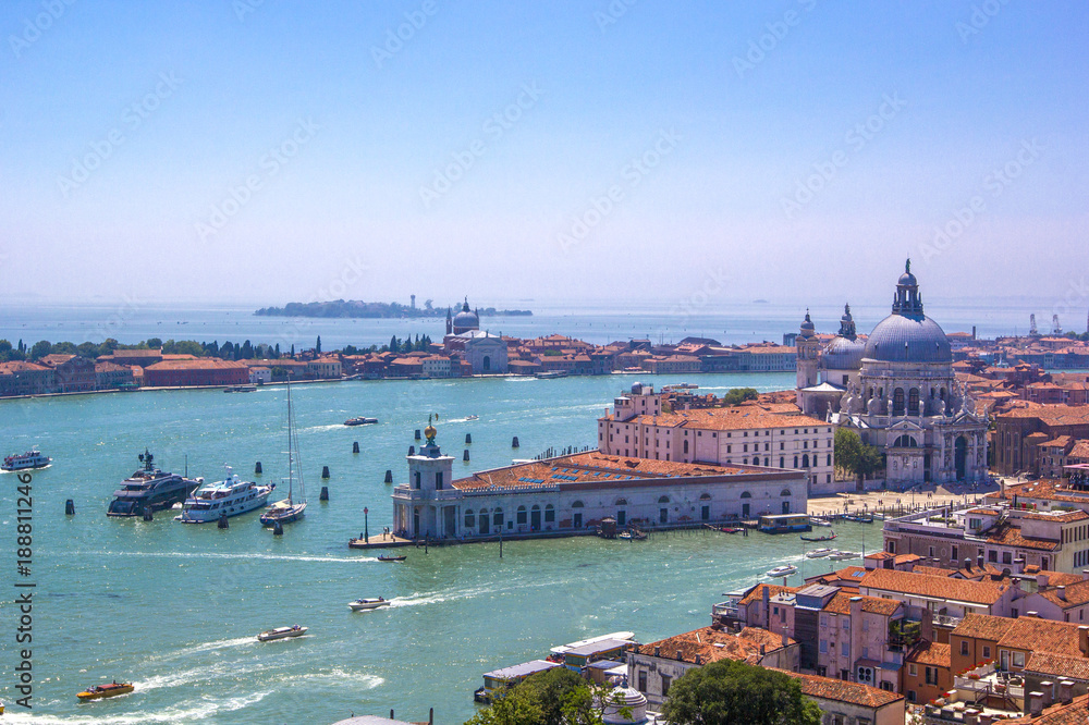Panorama  of Italian houses with red tiled roofs, Adriatic sea and Grand Canal with boats and gondolas, ships and boats, romantic city on water, Venice, Italy. Top view.
