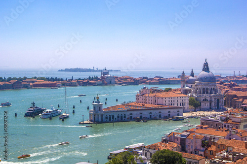 Panorama of Italian houses with red tiled roofs, Adriatic sea and Grand Canal with boats and gondolas, ships and boats, romantic city on water, Venice, Italy. Top view.