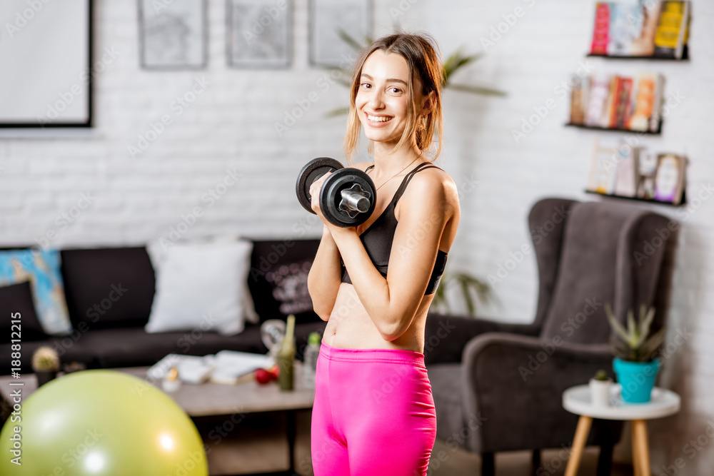 Portrait of a young woman doing sports with dumbbells at home Portrait of a young woman doing sports with dumbbells at home