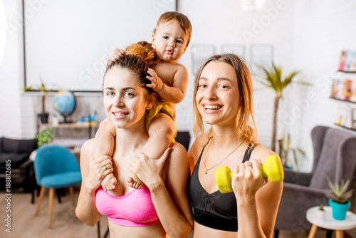 Portrait of a two women in sportswear with baby boy during the exercise at home