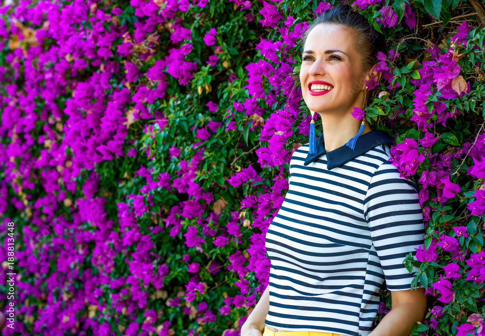 woman near colorful magenta flowers bed looking into distance woman near colorful magenta flowers bed looking into distance