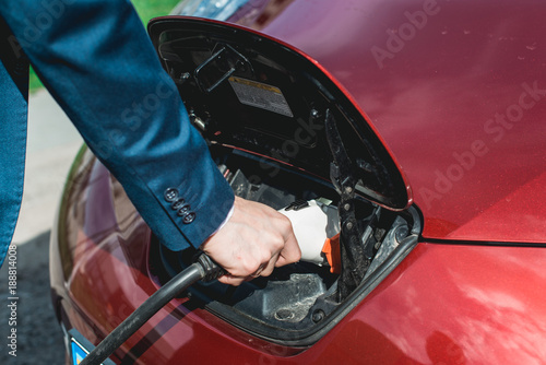 man charging battery of an electric car