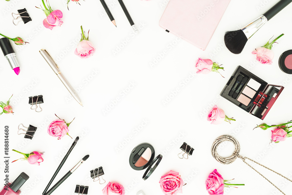 Female workspace with cosmetics, accessories and pink roses on white background. Top view. Flat lay. Beauty blog