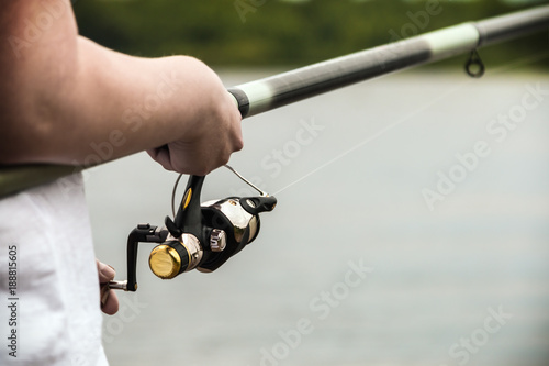 hand holding the rod and reel. Fishing accessories