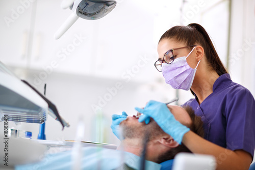 Young female dentist repairing patient's tooth