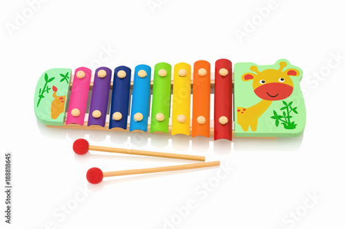 Rainbow colored wooden toy xylophone isolated on white background with shadow reflection. Colorful wooden metallophone toy isolated on a white background. Xylophone with sticks. photo