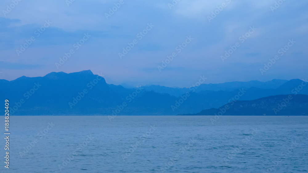 Unscharfe Silhouette der Berge am Gardasee zur Blauen Stunde