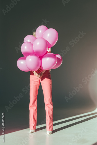 stylish woman holding pink balloons for holiday
