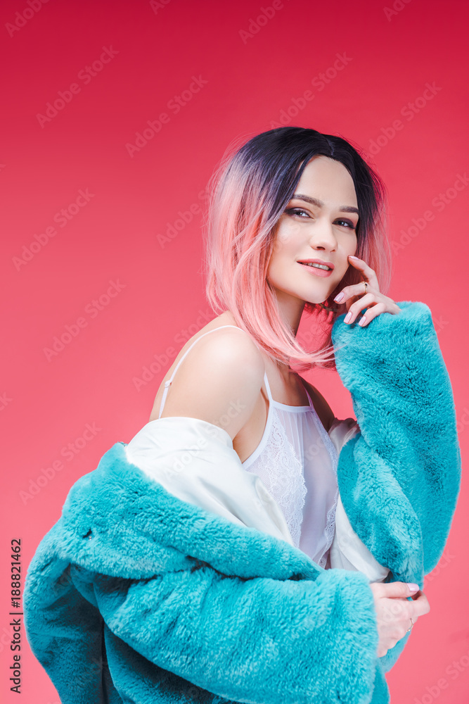 stylish smiling girl posing in lace bodysuit and blue fur coat, isolated on pink stylish smiling girl posing in lace bodysuit and blue fur coat, isolated on pink