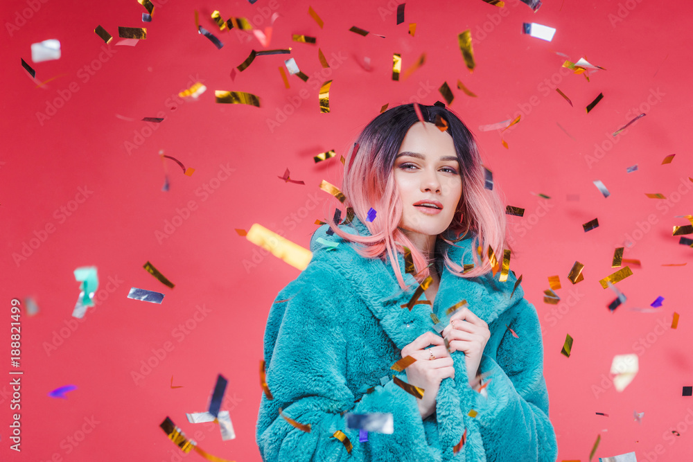 stylish glamour girl with pink hair posing in blue fur coat, isolated on pink with confetti - obrazy, fototapety, plakaty 