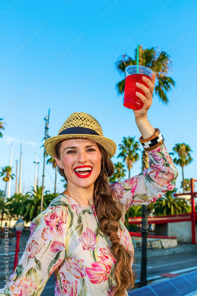 Fototapeta premium tourist woman in Barcelona with red beverage having fun time