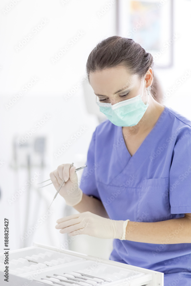 Female dentist holding dental instruments in surgery Female dentist holding dental instruments in surgery