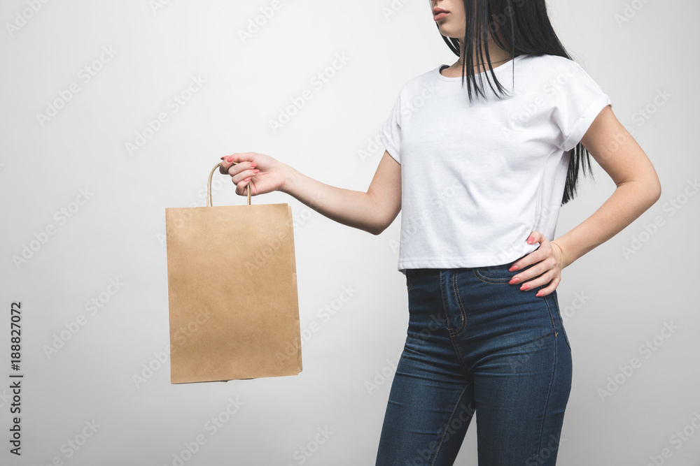 cropped shot of young woman in blank t-shirt on white with shopping bag cropped shot of young woman in blank t-shirt on white with shopping bag