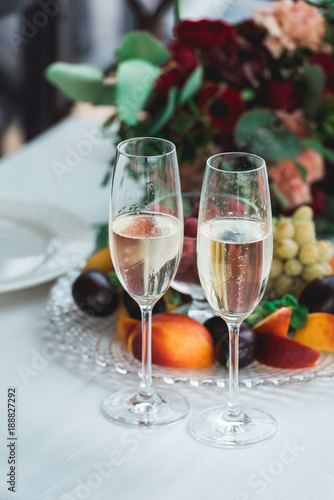 Glasses with champagne drink on a table. Happy newlyweds drinking. Loving couple created new family. photo