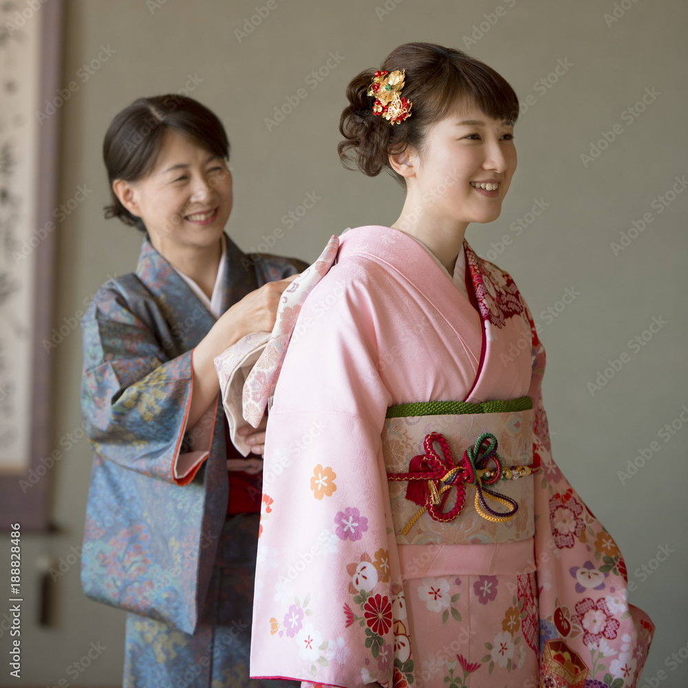 母親に着付けをしてもらう娘 母親に着付けをしてもらう娘